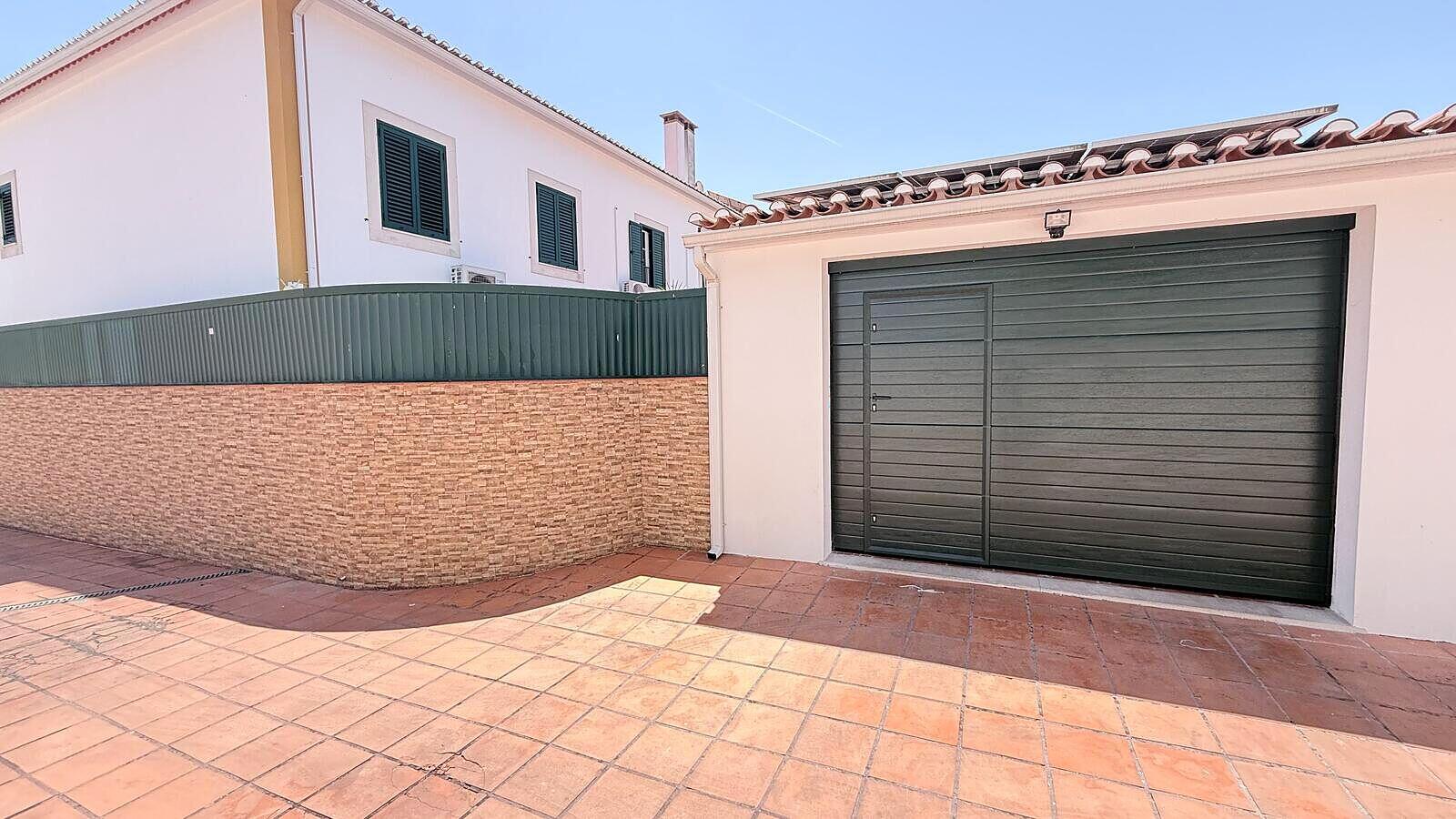 Portão seccionado cinzento instalado numa garagem